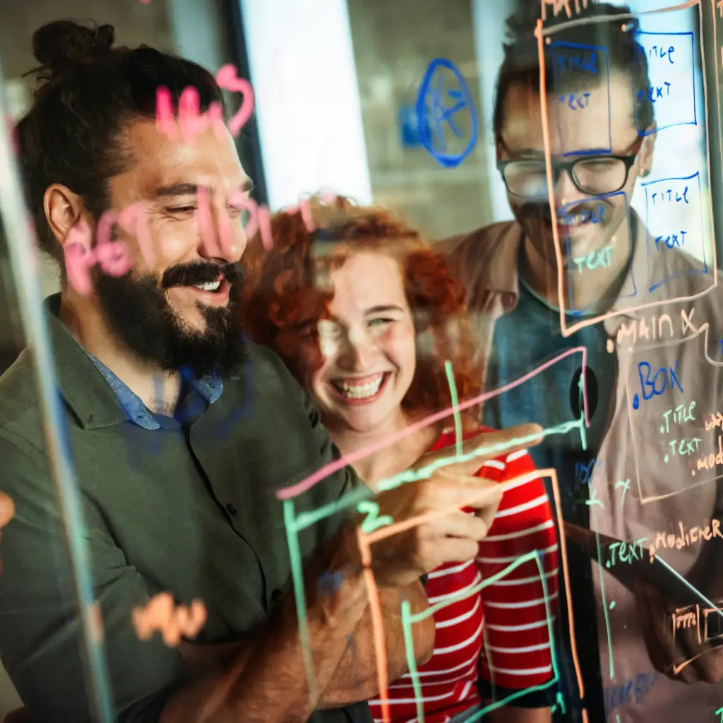A group of digital marketers working on landing page strategy on a window board.