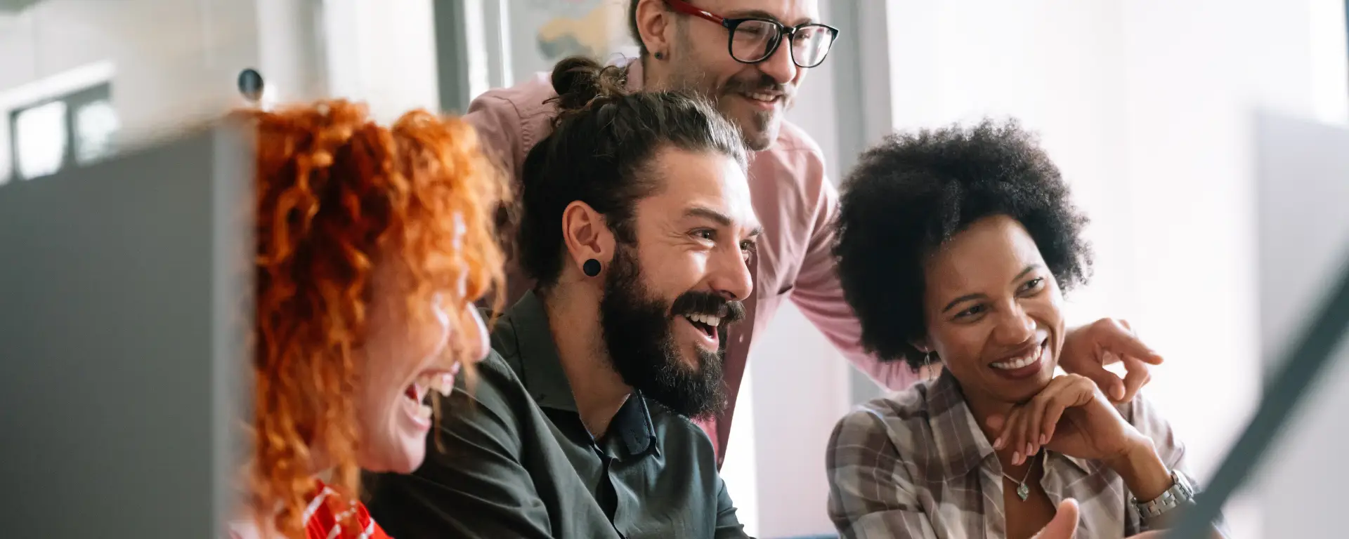 A team of Parilon Digital professionals collaborating in a modern office setting, engaging in a lively discussion around a table with laptops, notebooks, and coffee cups. The atmosphere reflects teamwork, creativity, and a dynamic workplace environment.